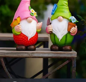 Detail der Garten-Gnome im Erdbeer- und Wassermelonen-Design auf einer Holzbank