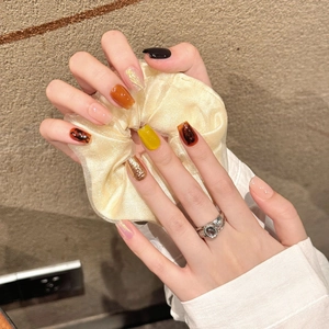 Handmade press-on nails featuring amber texture and gold leaf design for autumn
