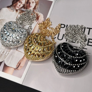 Close-up of heart-shaped mini rhinestone crossbody bags in silver, gold, and black colors