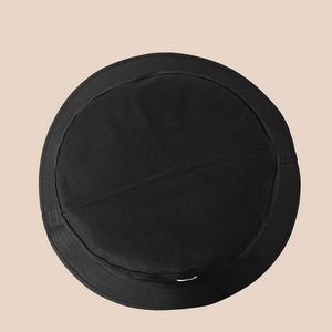 Dettaglio del cappello a secchiello nero con cuciture rinforzate e struttura piatta