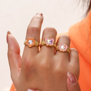 Detail of gold ribbed rings with butterfly and floral drip oil patterns and crystals