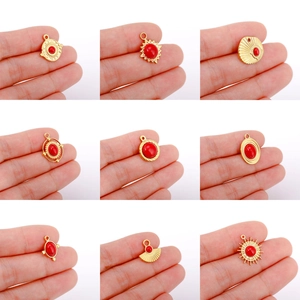 Detailed macro view of nine 18K gold-plated sun pendants with central red natural stone
