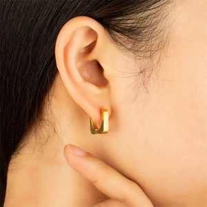 Minimalist square geometric hoop earrings in polished gold finish on female model