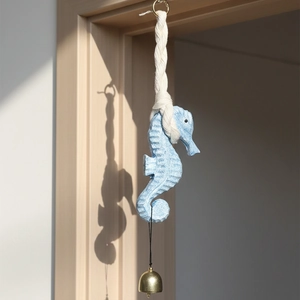 Light blue seahorse wood wind chime hanging on door frame with golden bell