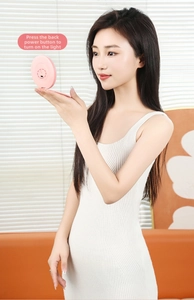 Detail of pink mini portable LED makeup mirror with back power switch button
