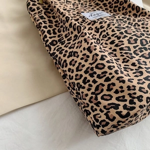 Close-up of leopard print canvas bag featuring detailed fabric texture and a white woven label