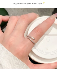 Close-up of elegant zircon paved snake ring worn while holding a coffee cup
