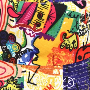 Détail d'un bob en toile imprimé graffiti coloré montrant les coutures et la texture