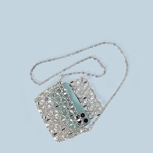 Silver beaded flower bag detail showing intricate hollow weave and metallic chain strap