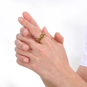 Detailed view of stackable gold-plated Cuban chain link rings worn on a hand