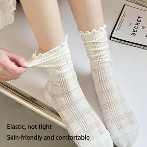 Chaussettes JK blanches à carreaux roses avec bordure volantée portées sur modèle