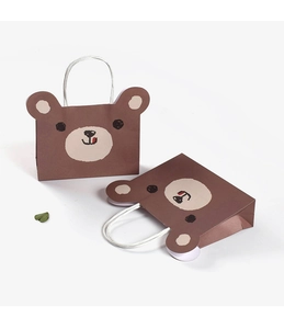 Detail of cute brown bear cartoon paper gift bag with white woven handles and green leaf