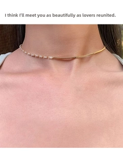 Detailed close-up of a half-snake chain and rectangular zircon gold necklace on a neck