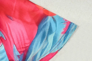 Detailed view of abstract pink and blue water-ink print on lightweight fabric cuffs