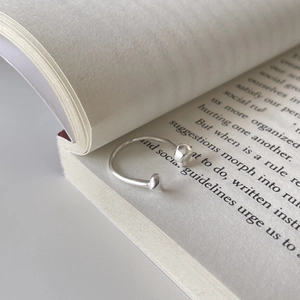 Macro shot of an irregular S925 sterling silver open ring on an open book page