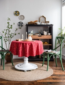 Detail of red Christmas tablecloth with gold snowflake patterns on a round dining table