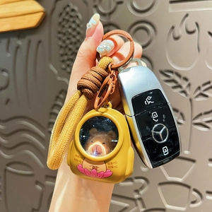 Cute capybara glowing keychain with woven rope strap attached to luxury car keys