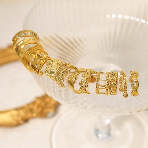 French vintage 18K gold plated cuff earrings set displayed on a stylish glass cup