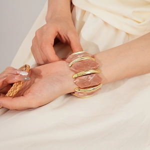 Détail du bracelet élastique avec résine marbre rose et modules en métal doré