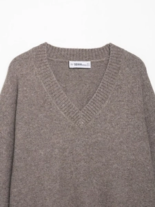 Detailed view of V-neckline and soft taupe knit texture on classic women's sweater