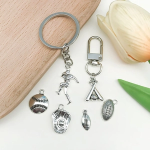 Set dettagliato di ciondoli sportivi in argento con temi baseball e rugby su sfondo legno
