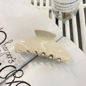 Minimalistische beige Haarspange aus Acetat auf einem Lifestyle-Magazin Hintergrund