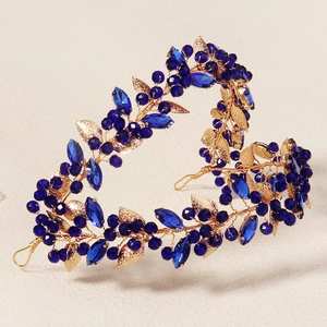 Detailed view of handmade gold bridal headband with blue rhinestones and leaf motifs