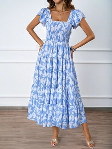 Détail de robe longue à fleurs bleues avec décolleté carré et corsage smocké élégant