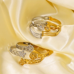 Two-tone gold and silver open bangles with hollow flower and star patterns on silk fabric