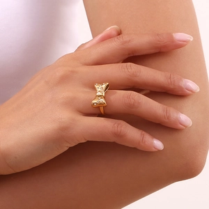 Close-up of 18K gold plated bow ring with pavé crystals worn on model's finger