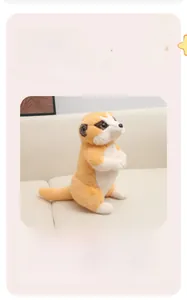Close-up of a plush meerkat doll with soft orange and white fur on a beige sofa