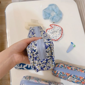 Detail view of the floral canvas pencil case with a sturdy blue zipper and soft fabric texture