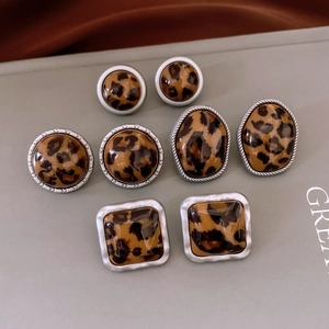Lot détaillé de quatre paires de boucles d'oreilles léopard aux formes géométriques