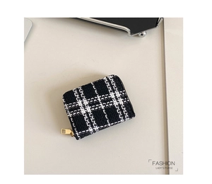 Close-up of black and white tweed patterned lady's coin purse with golden zipper detail