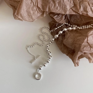 Minimalist 925 sterling silver ball chain necklace with T-bar toggle clasp on brown paper