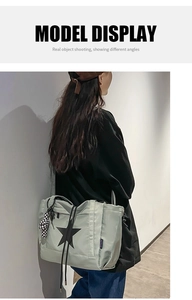 Detail view of water-resistant nylon tote bag with black star print and checkered charm