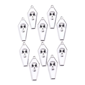 Detail of 10-piece white enamel coffin pendants with skull patterns and silver metal finish