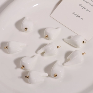Macro shot of 3D realistic tooth charms with golden hooks for DIY jewelry making