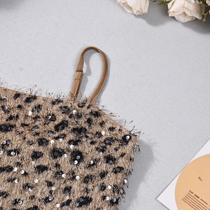 Gros plan sur un caraco léopard à paillettes et texture pelucheuse sur fond gris