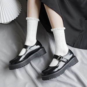 Calze bianche con volant e scarpe Mary Jane in pelle verniciata nera indossate dal modello