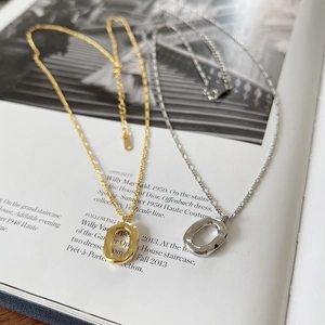 Close-up of gold and silver S925 oval donut pendants on a fashion magazine background