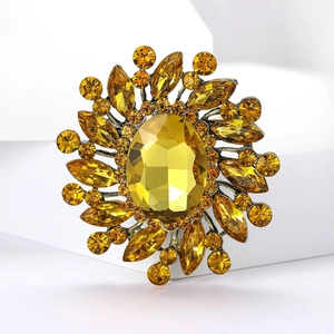 Close-up of vintage sunflower brooch with yellow faceted crystals and bronze alloy base
