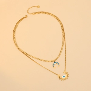 Detailed shot of gold layered crescent moon and sunburst necklace with blue evil eyes