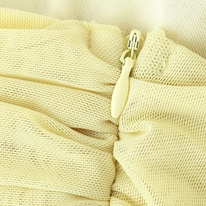 Elegant tube mesh dress detail showing invisible zipper and soft yellow tulle fabric
