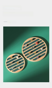 Detailed top view of bamboo wood jewelry tray with green velvet slots for rings