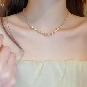 Macro detail of irregular shell beads and gold spacers on a vintage choker necklace