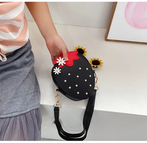 Detail of black strawberry shaped girls crossbody bag with gold studs and floral accents