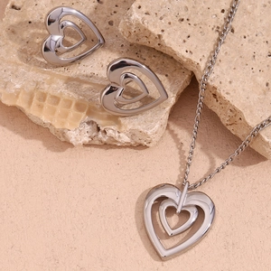 Detail of silver hollow double heart pendant necklace and matching stud earrings set