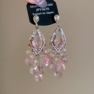 Detail of pink crystal butterfly wing earrings with long tassels on a display card