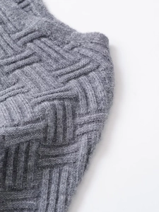 Close-up of gray knit fabric showing the intricate texture and weaving craftsmanship